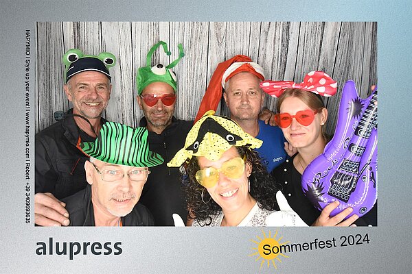 Mitarbeitende von Alupress in der Fotobox beim Sommerfest